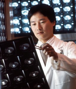 un médico revisa los escáneres cerebrales para detectar lesiones cerebrales traumáticas