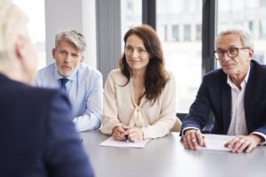 jurors at a table being questioned by a lawyer