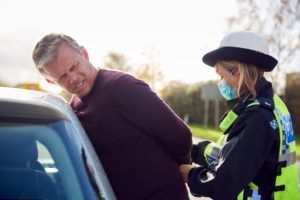 male driver being arrested by police officer