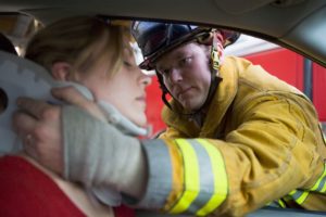 Bomberos ayudando a una mujer herida en un accidente automovilístico