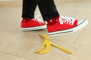 Niño con zapatos converse resbalando en una cáscara de plátano