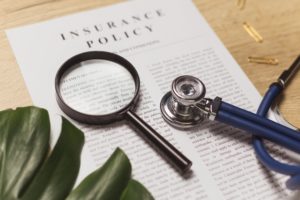 stethoscope sittng atop insurance paperwork