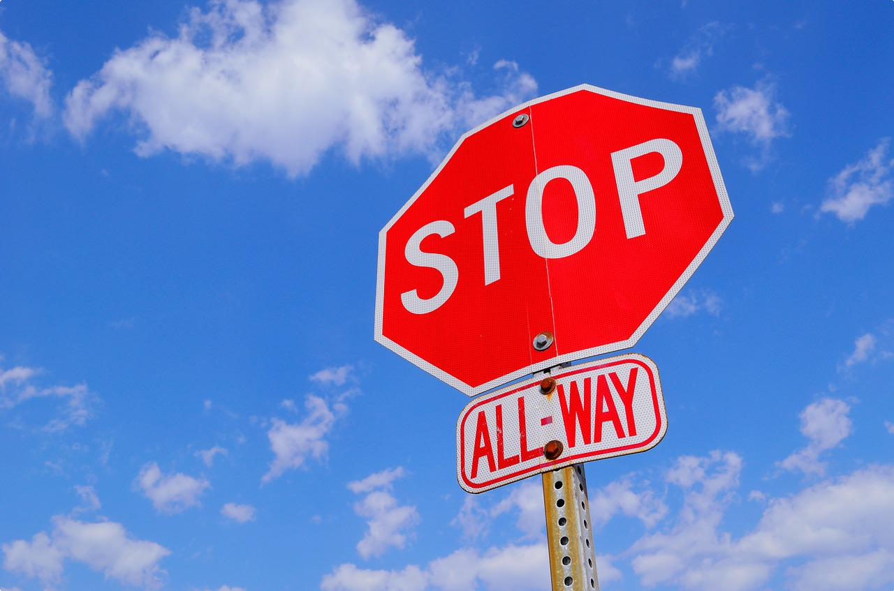 Red stop sign with blue sky background