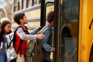 autobús escolar y niños subiendo