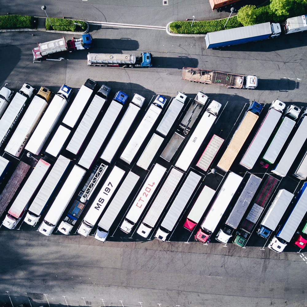 Tractor trailers parked in lines in parking lot