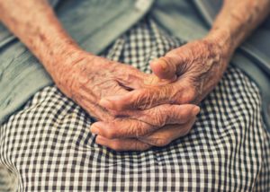 Pair of wrinkled hands clasping each other