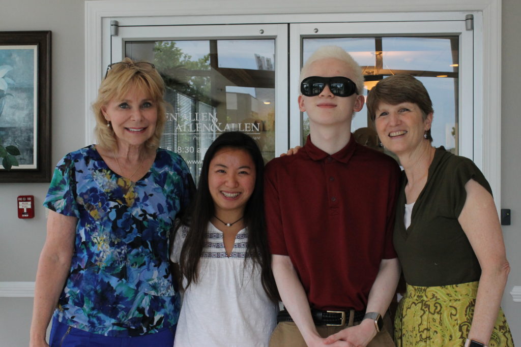 Four people smiling outside of Allen & Allen office