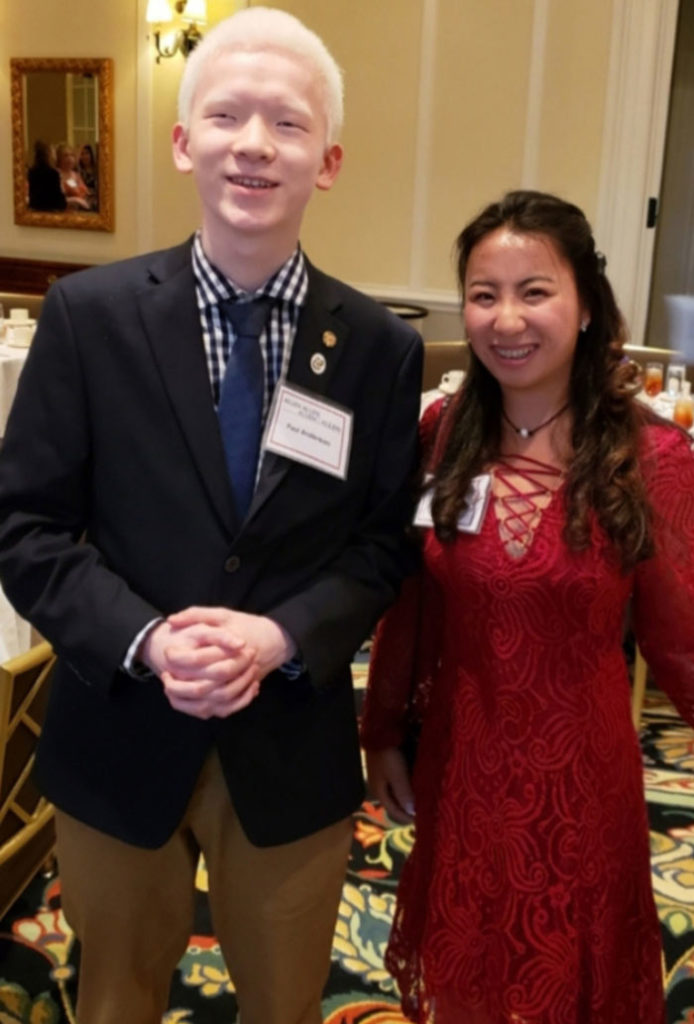 Two smiling people standing next to each other