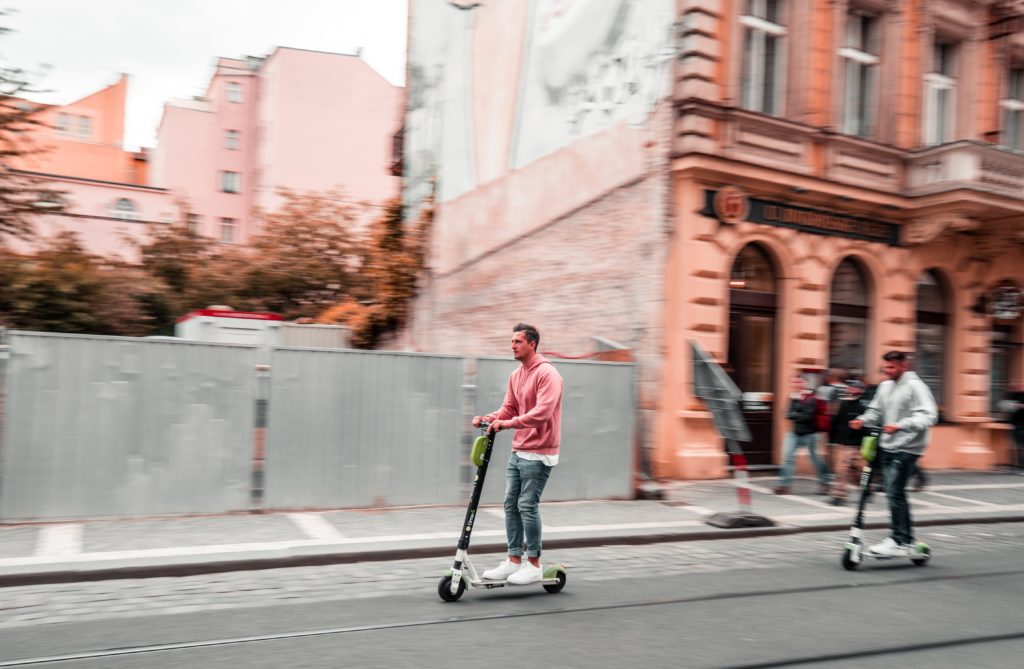People riding electric scooters down the street