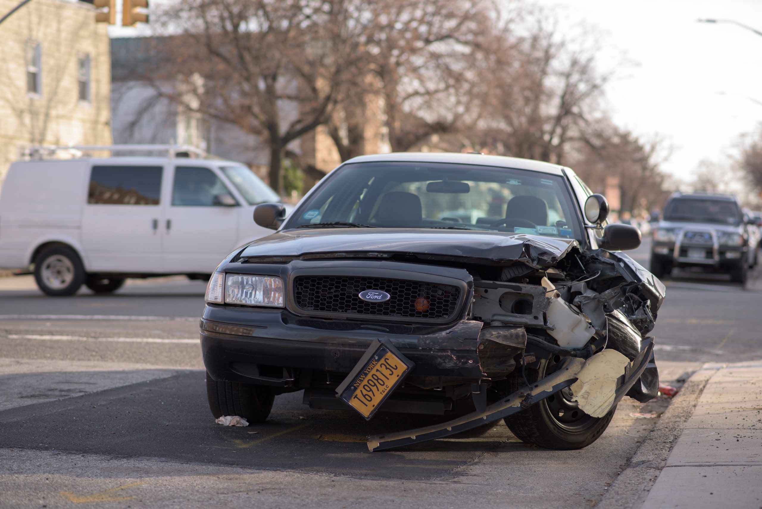 Black car with New York license plate with damage to front left light