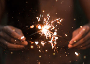 Black person golding sparklers