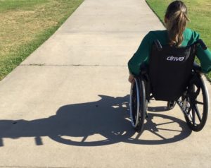 Woman in wheelchair on sidewalk