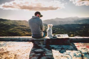 man and his dog overlooking a vista