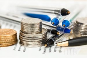 calculating insurance, coins, pens and paper