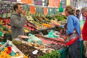 hombre vendiendo productos en un mercado de agricultores