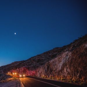 headlights on cars on a mountain road at dusk