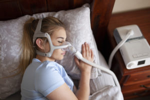 Young female sleeping with cpap machine for sleep apnea