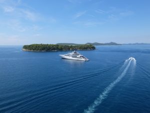 Yacht and speedboat out on the water with an island nearby