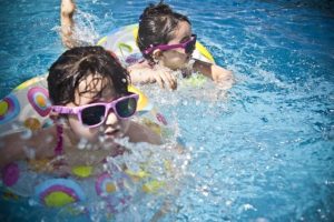 niños nadando en una piscina