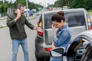 hombre y mujer discutiendo después de un accidente de coche