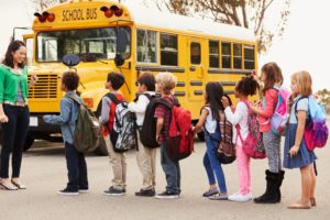 niños frente a un autobús escolar