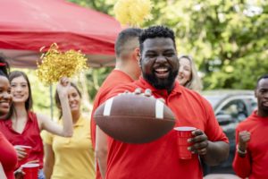 man holding football at tailgate party