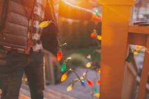 someone stringing up house lights for christmas