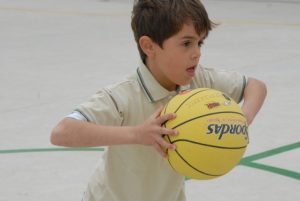 elementary school child playing basketball