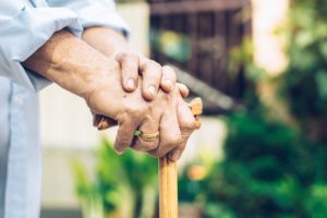 elderly person walking with a cane