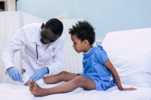 niño herido con médico negro