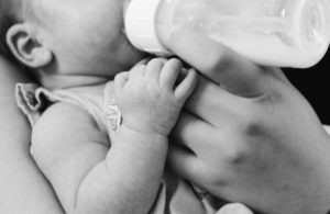 baby drinking formula from a bottle