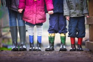 pies y piernas de niños parados en la parada de autobús