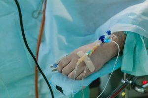 mano conectada a IV en el hospital debido a envenenamiento por benceno