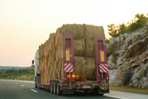 truck on highway loaded with bales of hay