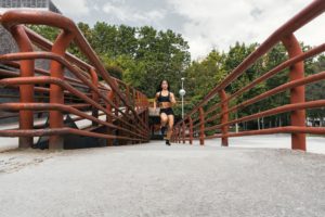 mujer musculosa corriendo por el puente