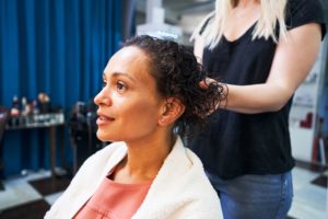 mujer negra que recibe un tratamiento relajante para el cabello