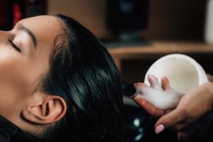 Black woman getting her hair relaxed