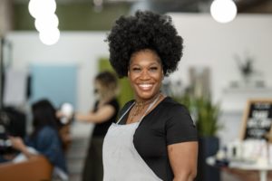 Black hair salon owner smiling