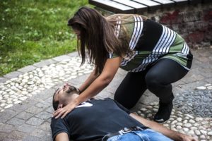 woman trying to help unconscious man