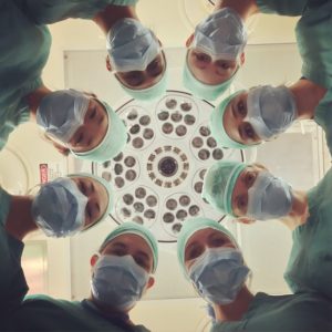 círculo de médicos mirando hacia abajo en la mesa de operaciones