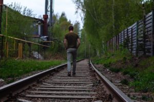 hombre caminando sobre las vías del tren