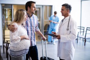 Pregnant lady and husband consult with doctor