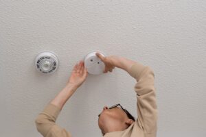 person tinkering with carbon monoxide detector