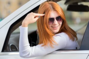 Angry red haired woman driving a car