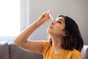 woman applying eye drops