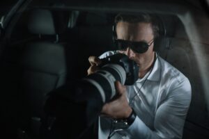 Man in car with shade and a high-powered lens