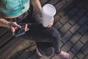 person drinking a to go cup of coffee