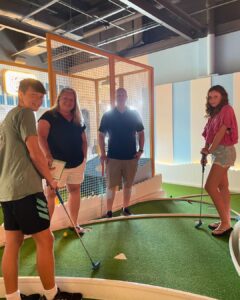 People playing indoor mini golf