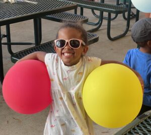Little gil holding balloons