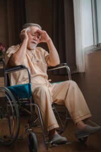 anciano deprimido en un asilo de ancianos sentado en silla de ruedas